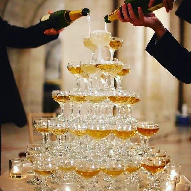 Фонтан из шампанского на свадьбу и торт из пирожных как неотъемлемая часть в свадебном меню