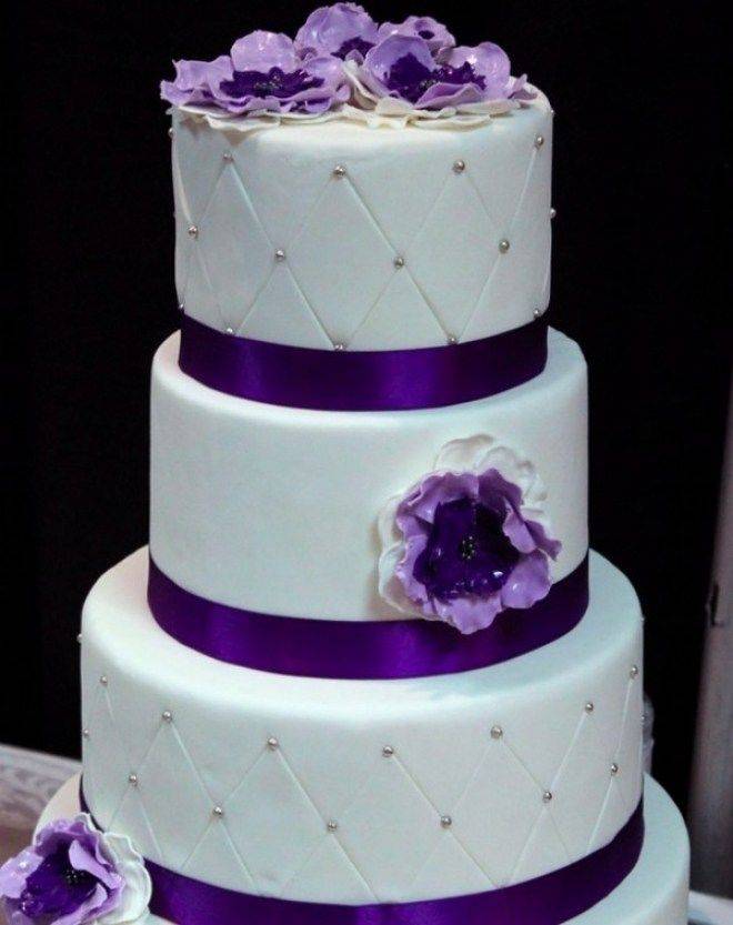 Фиолетовый торт на свадьбу с кремовыми и живыми цветами, фигурками, лентами