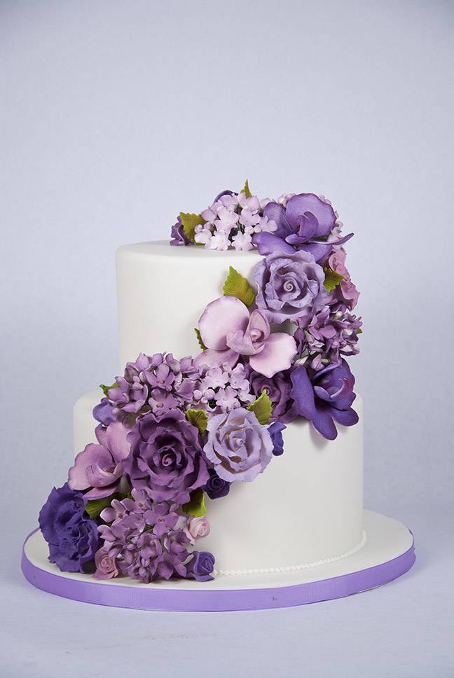 Фиолетовый торт на свадьбу с кремовыми и живыми цветами, фигурками, лентами