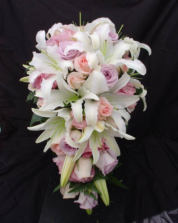 Символ преданности – свадебный букет из лилий в сочетании с розами и другими цветами на фото
